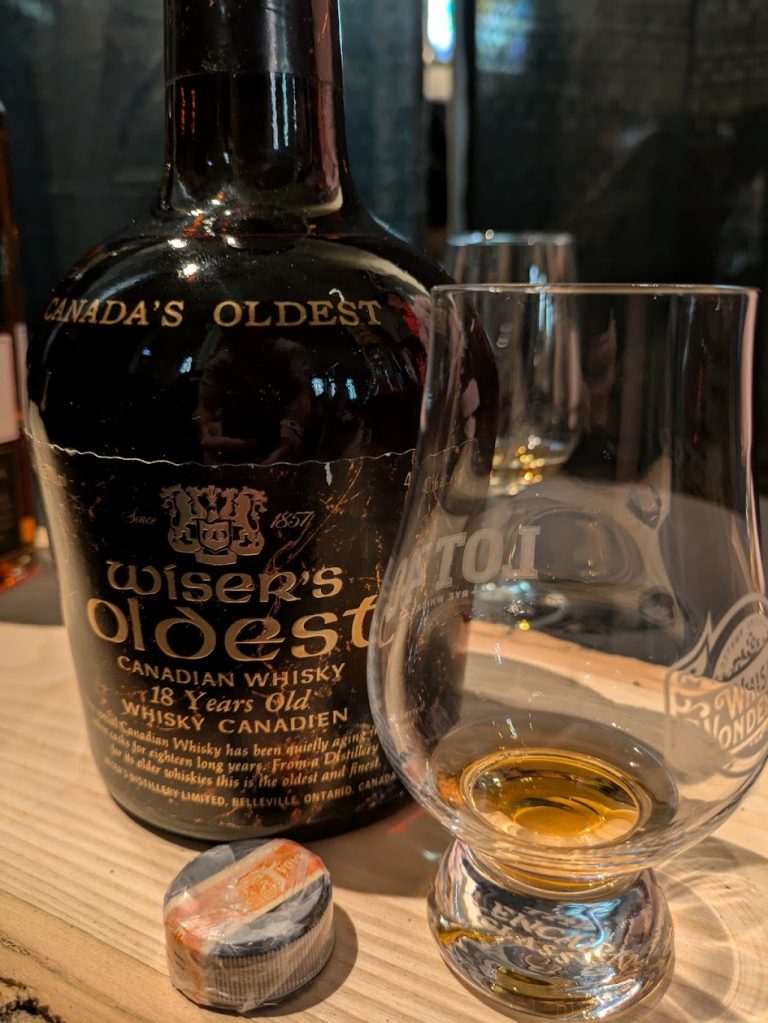 A bottle of Wiser’s whisky beside a tasting glass.