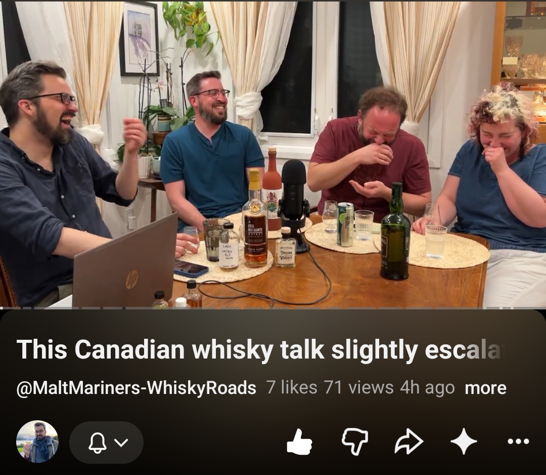 Four participants laughing around a table with whisky bottles and a microphone during the COWS conversation on Malt Mariners’ Whisky Roads channel.
